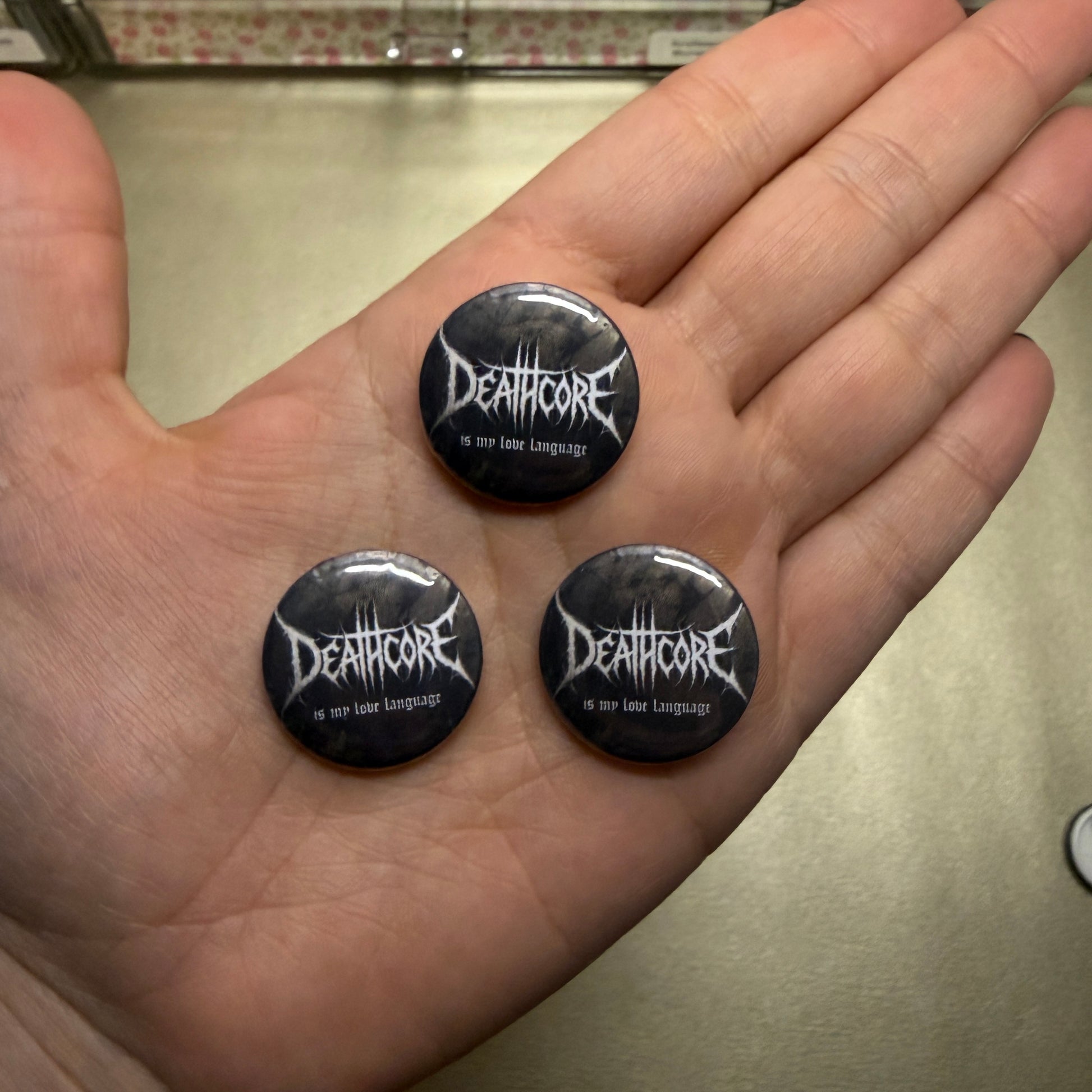 Drei Buttons. Schwarz mit Deathcore is my love language.