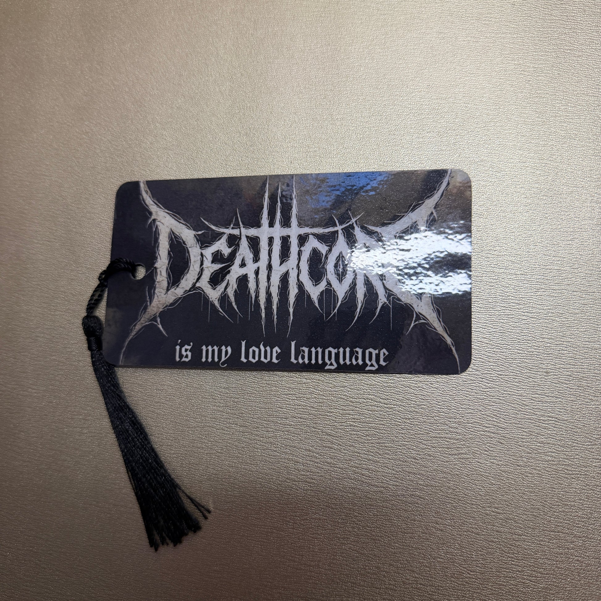 Schwarze Lesezeichen mit schwarzen Quasten mit dem Schriftzug "Deathcore is my love language." 