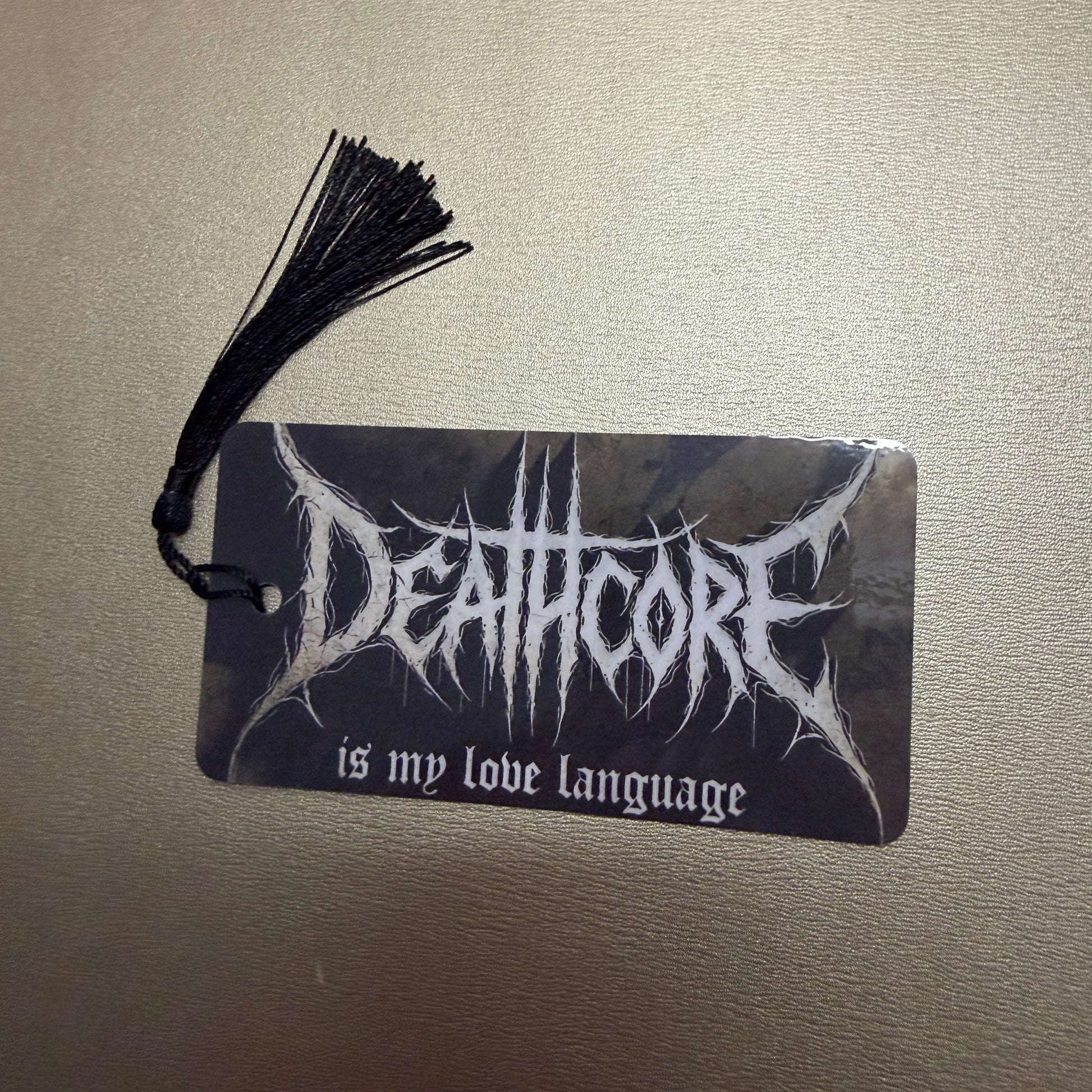 Schwarze Lesezeichen mit schwarzen Quasten mit dem Schriftzug "Deathcore is my love language." 